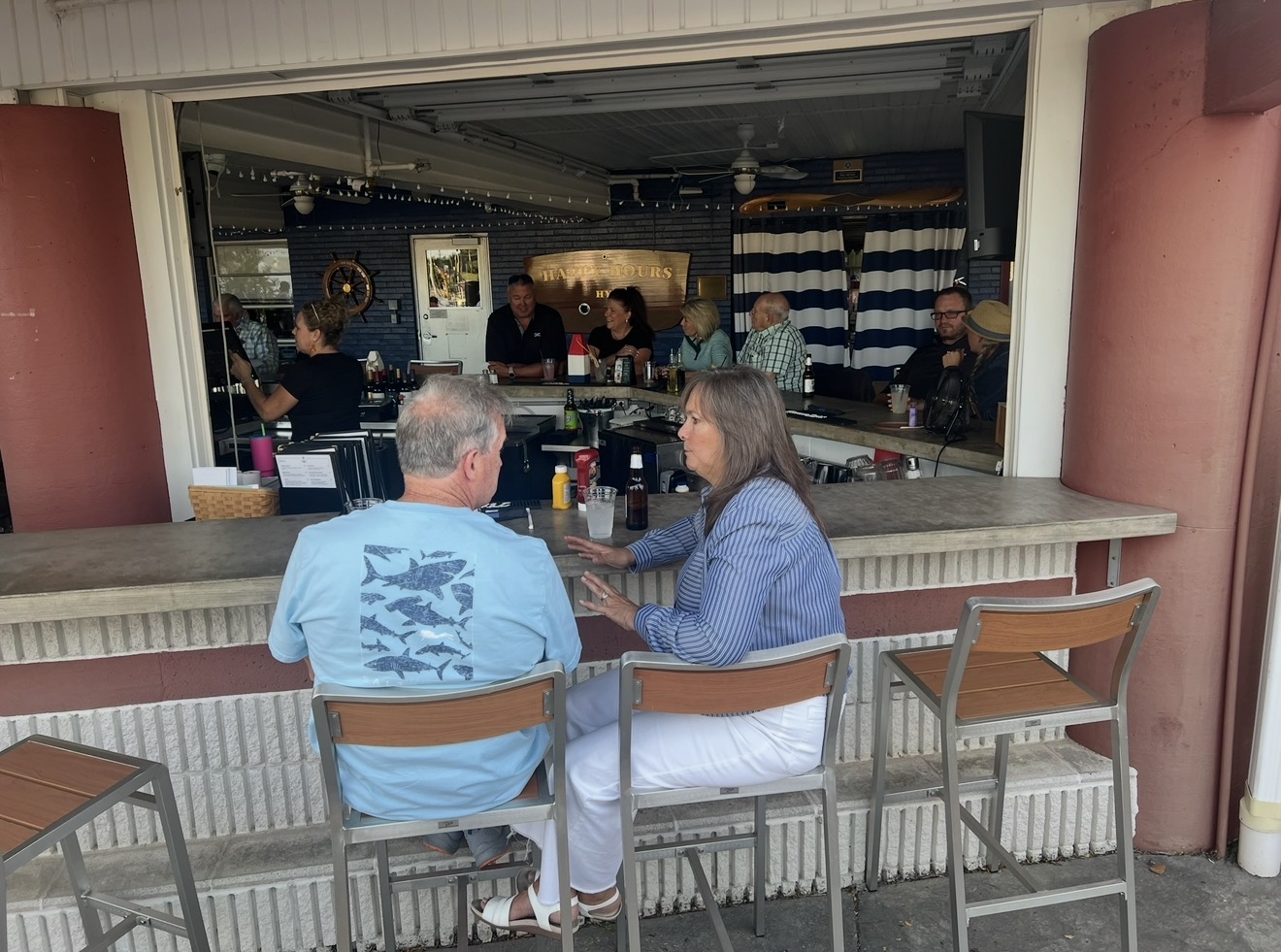 Guests seated at the riverfront patio bar